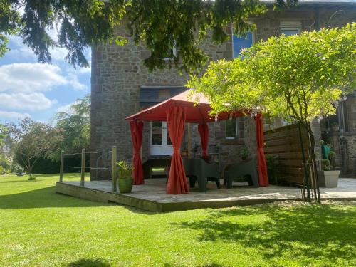 une tente rouge sur une terrasse dans une cour dans l'établissement La Jackal, à Ploubezre