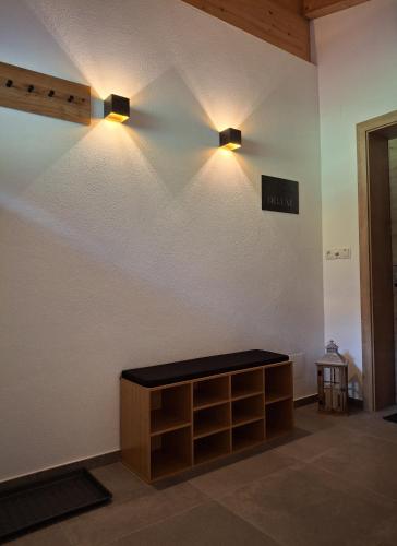 a room with two lights on the wall and a shelf at Appartement Glücksschmiede im Zillertal in Stumm