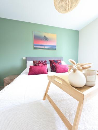 une chambre avec un lit blanc avec des oreillers roses dans l'établissement Villa Evasion 10 pers Clim, à Saint-Martin-de-Londres