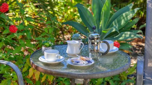 a table with tea cups and saucers on it at Emerald Gardens Motel & Apartments in Emerald