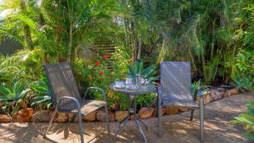 two chairs and a table in a garden at Emerald Gardens Motel & Apartments in Emerald