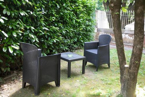 three chairs and a table next to a tree at Villa Giove Rooms in Prato