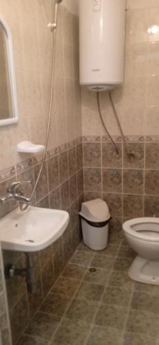 a bathroom with a sink and a toilet at Къща за гости in Primorsko