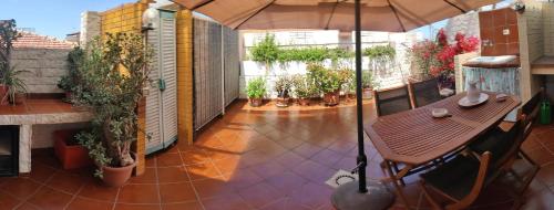 a patio with a wooden table and an umbrella at La Casa di Gianna in Sassari