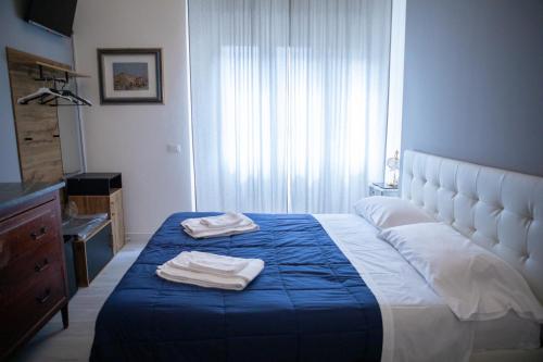 a bedroom with a bed with two towels on it at Villa Giove Rooms in Prato