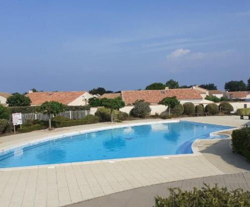 une grande piscine bleue dans un complexe dans l'établissement House in private residence , beach and pool access, à Bretignolles-sur-Mer