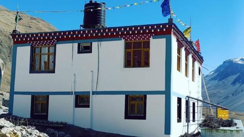 a white building with a flag on top of it at LSN Homestay By Soma Stays in Kaza