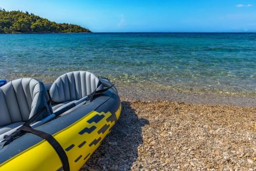 a yellow raft sitting on a beach next to the water at Beautiful Torch Lake House with Beach Access home in Rapid City