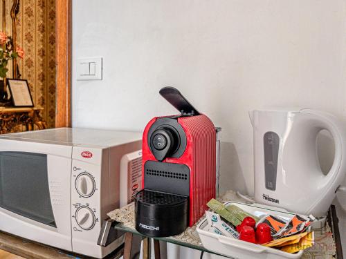 a microwave and a red router on a table next to a microwave at Mare 400m - Free Parking - WiFi in Varazze