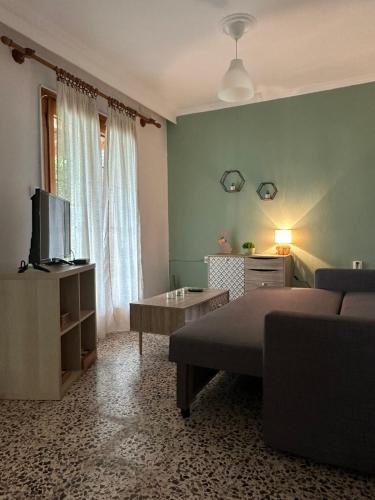 ein Schlafzimmer mit einem Bett und einem Fernseher in der Unterkunft Με Θεα!! in Stomio
