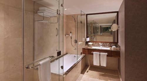 a bathroom with a shower and a tub and a sink at InterContinental Amman Jordan by IHG in Amman