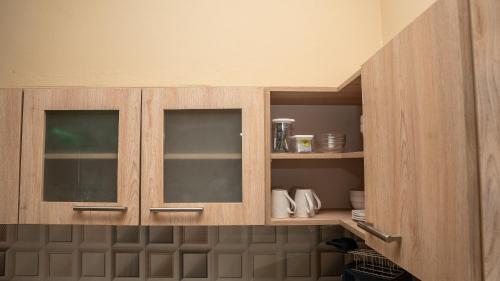 a cabinet with two glass doors in a kitchen at Ti Caz Mathurin in Port Mathurin