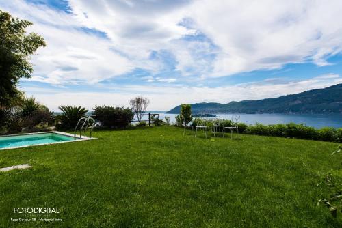 a lawn with a pool and a view of the water at B&B Renalù in Verbania