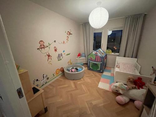 a baby room with a crib and a childs bedroom at Child-friendly villa with outdoor lounge, close to beach & golf in Halmstad