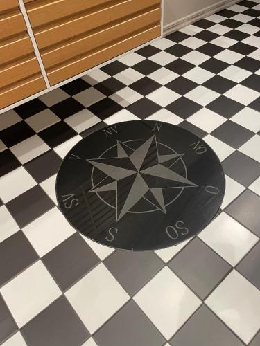 a black rug on a black and white tiled floor at Child-friendly villa with outdoor lounge, close to beach & golf in Halmstad