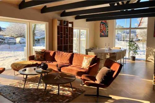 a living room with a couch and chairs and a table at Child-friendly villa with outdoor lounge, close to beach & golf in Halmstad