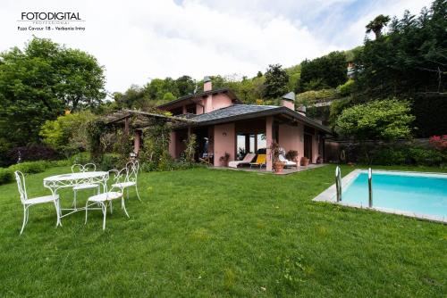 a house with a table and chairs and a pool at B&B Renalù in Verbania