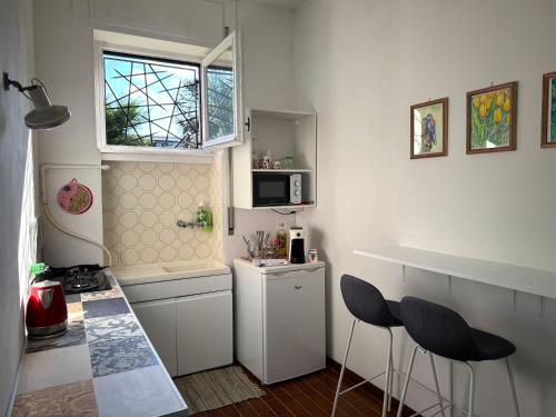 a kitchen with a counter and two stools in it at Casa Natura in Cernobbio