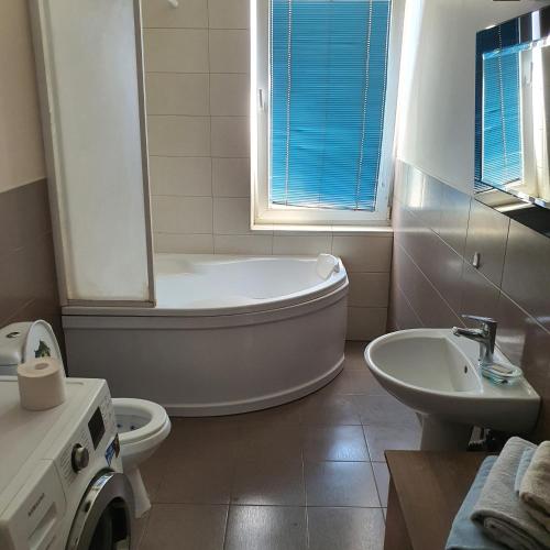 a bathroom with a tub and a toilet and a sink at Apartment Beauty in Vilnius