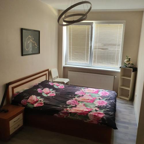 a bedroom with a bed with flowers on it at Apartment Beauty in Vilnius