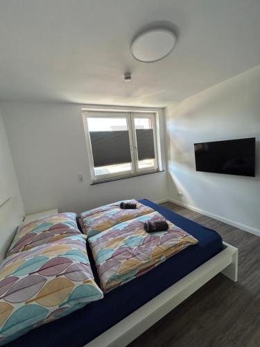 a bedroom with a bed and a flat screen tv at Ferienwohnung am Uniklinik Lübeck in Lübeck