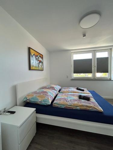 a bedroom with a bed and a table and two windows at Ferienwohnung am Uniklinik Lübeck in Lübeck
