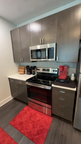a kitchen with a stove and a microwave at The 513 Flat-1BR, 1 Bath Apmt with Pool and Riverfront View Only Steps from The banks & Stadiums in Cincinnati
