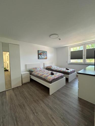 two beds in a room with wooden floors at Ferienwohnung am Uniklinik Lübeck in Lübeck