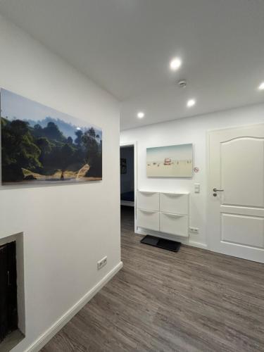 a living room with a fireplace and a painting on the wall at Ferienwohnung am Uniklinik Lübeck in Lübeck