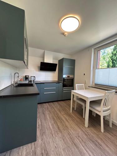 a kitchen with blue cabinets and a table and chairs at Ferienwohnung am Uniklinik Lübeck in Lübeck