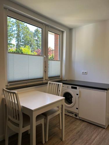 a kitchen with a table and chairs and a washing machine at Ferienwohnung am Uniklinik Lübeck in Lübeck