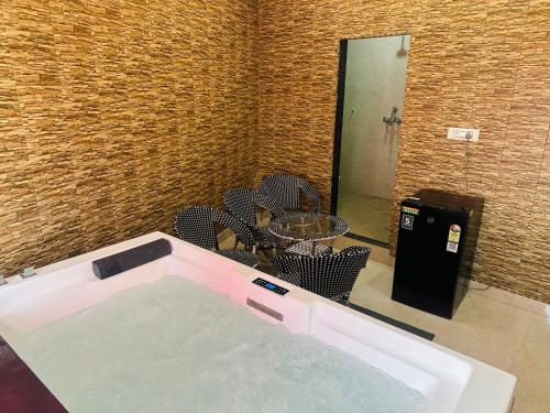 a bath tub with a table and chairs in a room at hotel deep palace in Varanasi