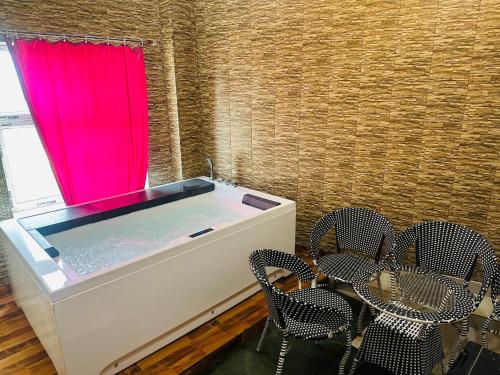 a hot tub with chairs and a red curtain at hotel deep palace in Varanasi