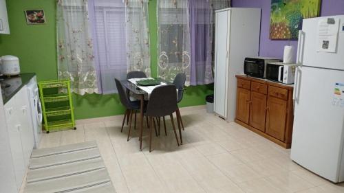 a kitchen with a table and chairs and a refrigerator at Charming T1 apartment in Seixal in Aldeia de Paio Pires