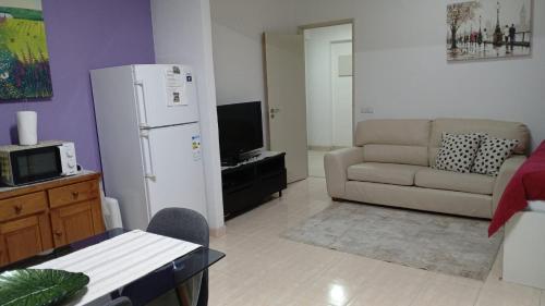 a living room with a white refrigerator and a couch at Charming T1 apartment in Seixal in Aldeia de Paio Pires