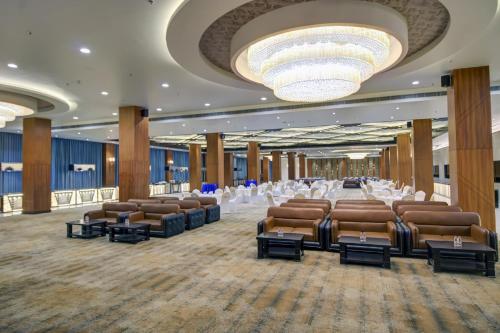 a large banquet hall with chairs and a chandelier at The Bindal Hotel in Jamshedpur