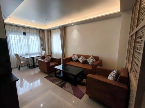 a living room with two couches and a table at The Bindal Hotel in Jamshedpur