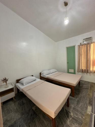 a room with two beds and a window at Sea LaVie Guesthouse in Siquijor
