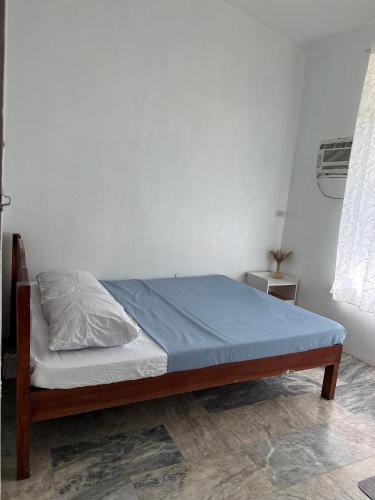 a bedroom with a bed with a blue bedsheet at Sea LaVie Guesthouse in Siquijor