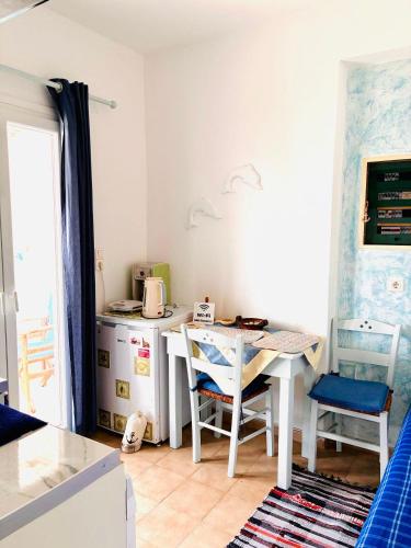 a kitchen with a table and chairs in a room at Casa Filareti-Triple studio with city wiew in Ios Chora