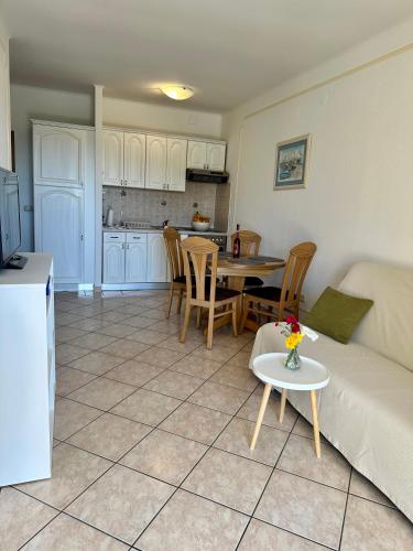 a living room and kitchen with a couch and a table at Colonia Apartments in Orebić