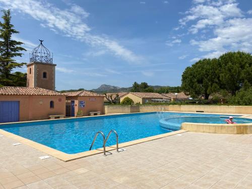 une piscine avec un phare en arrière-plan dans l'établissement Le petit Atelier, à Eyguières