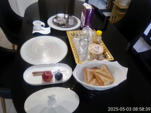 a black table with plates of food on it at Trojuan Inn Phakalane Surbab, Gaborone in Kgaphamadi