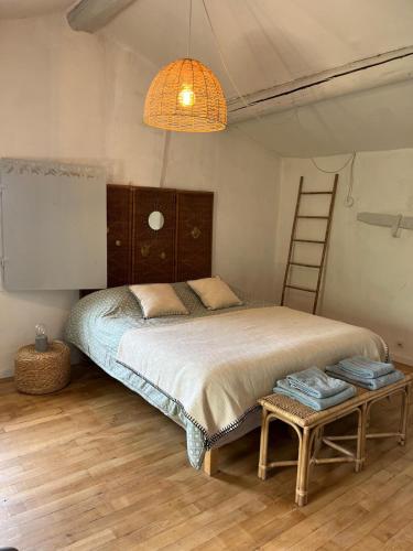 - une chambre avec un lit avec une échelle et une lampe dans l'établissement Mas de la bruissande, à Mazan