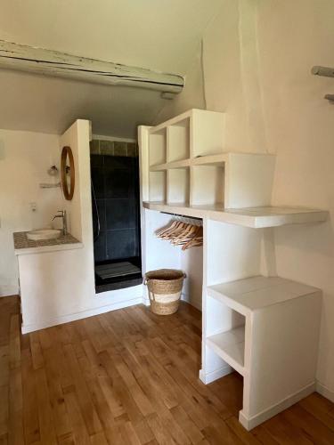 Cette chambre dispose d'étagères blanches et de parquet. dans l'établissement Mas de la bruissande, à Mazan