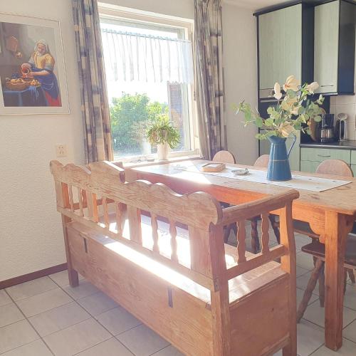 a dining room table with a bench in a kitchen at Vakantiehuisje Het Melkmeisje in Kaatsheuvel