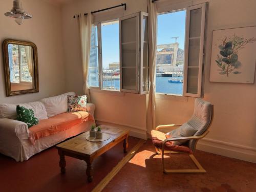 - un salon avec un canapé, une table et des fenêtres dans l'établissement Spacious 2-bed apartment with direct Port view, free parking, à La Ciotat