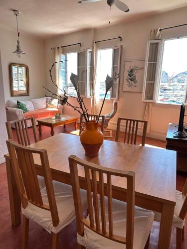 une table à manger avec un vase au-dessus dans l'établissement Spacious 2-bed apartment with direct Port view, free parking, à La Ciotat