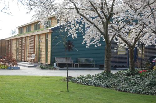 un bâtiment avec deux bancs et un arbre avec des fleurs blanches dans l'établissement Lelymare Logies, à Lelystad