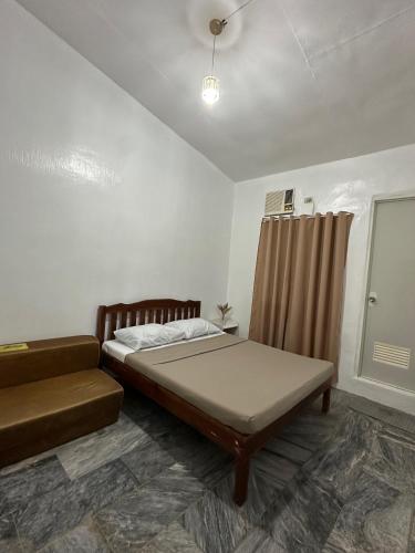 a bedroom with a bed and a couch in it at Sea LaVie Guesthouse in Siquijor